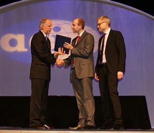 Jason Barrington (centre) and Luke Bisby (right) receive the Award from ACI President Jim White at the ACI Spring Convention in Minneapolis