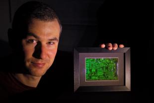Dr Philip Hands holding a hologram in a dark room